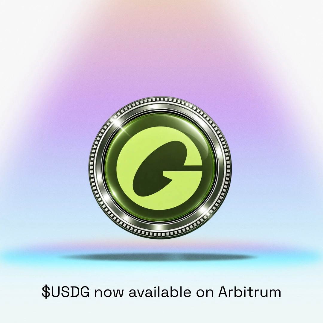 A promotional image showing a green coin-like logo with a stylized 'G' emblem, accompanied by the text '$USDG now available on Arbitrum' at the bottom.