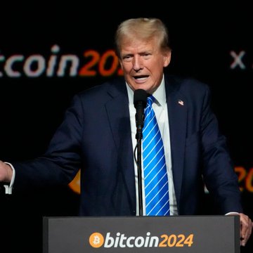 Donald Trump speaks at a podium during the Bitcoin 2024 conference, with the event's logo visible in the background and on the lectern, where the word "bitcoin2024" is clearly displayed alongside an orange Bitcoin symbol. The image ties to news of ongoing Senate negotiations over the CLARITY Act, which has reignited scrutiny of Trump's family crypto ventures and prompted Democrats to push for ethics restrictions limiting presidential crypto-related business profits.