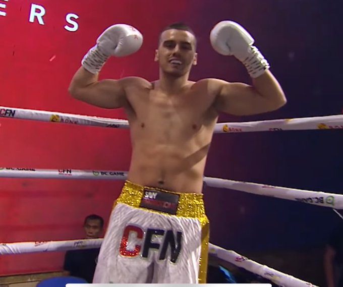 A shirtless boxer with white gloves triumphantly raises his arms in victory, sporting white and gold trunks emblazoned with "CFN" and "SWY" logos in a ring marked with "BC.GAME" branding. The image humorously reflects the "Crypto me" side of the meme, capturing the same exhilarating, victorious pose one might imagine striking after a major crypto win.
