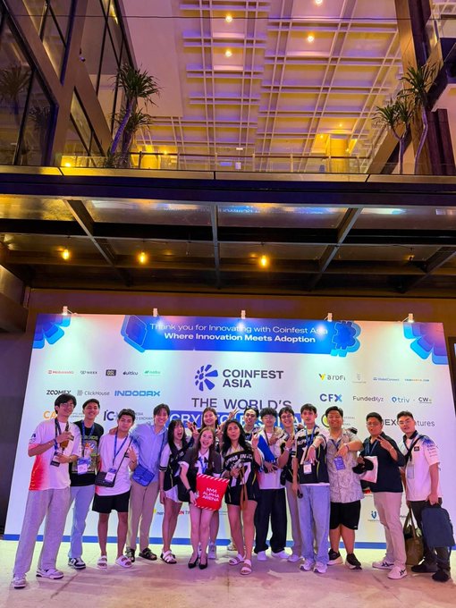 A group photo of young people posing in front of a backdrop for 'COINFEST ASIA', the 'WORLD'S FIRST CRYPTO FESTIVAL', with the text 'Thank you for Innovating with Confest Asia! Where Innovation Meets Adoption'.
