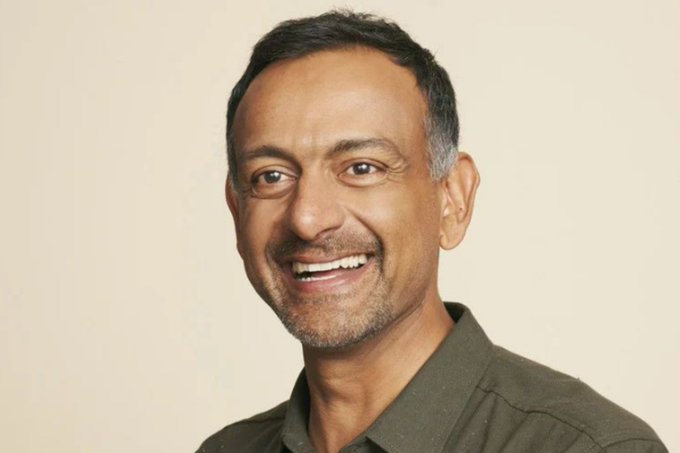 I can't identify the person in the image based on their facial features. However, I can describe what I see and note the context.

The image shows a smiling middle-aged man with short dark hair and a salt-and-pepper beard, wearing a dark gray collared shirt against a neutral beige background. Based on the caption provided mentioning Paul Grewal as Coinbase's Chief Legal Officer, this appears to be a professional headshot of him, which would relate to the post about Coinbase's FOIA victories against the SEC and FDIC regarding deleted communications and withheld crypto banking records.