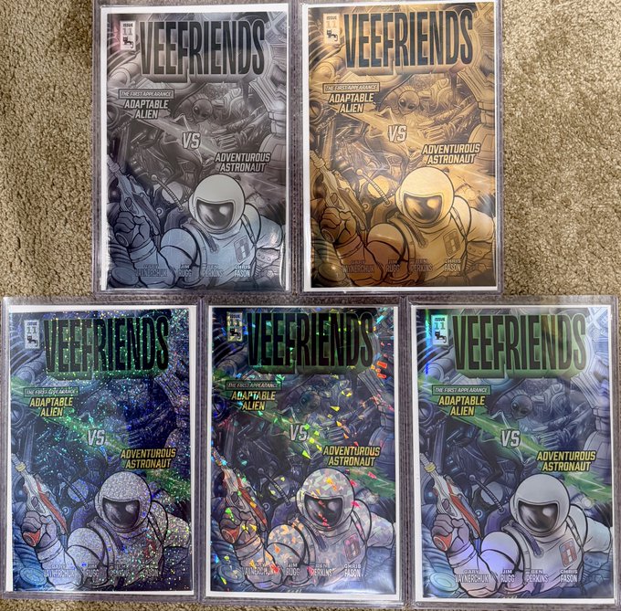 Five comic book covers titled 'VEEFRIENDS - THE FIRST ADVENTURE: ADAPTABLE ALIEN VS ADVENTUROUS ASTRONAUT' displayed in various colored editions (silver, gold, and holographic).