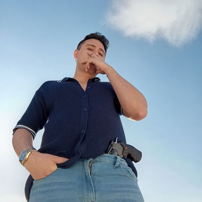 A man in a navy polo shirt and jeans poses with a gun tucked into his waistband, possibly representing a "tough guy" persona or a warning against being easily fooled. The accompanying post from @nft_dreww advises caution and skepticism regarding accusations in the #Web3 space.