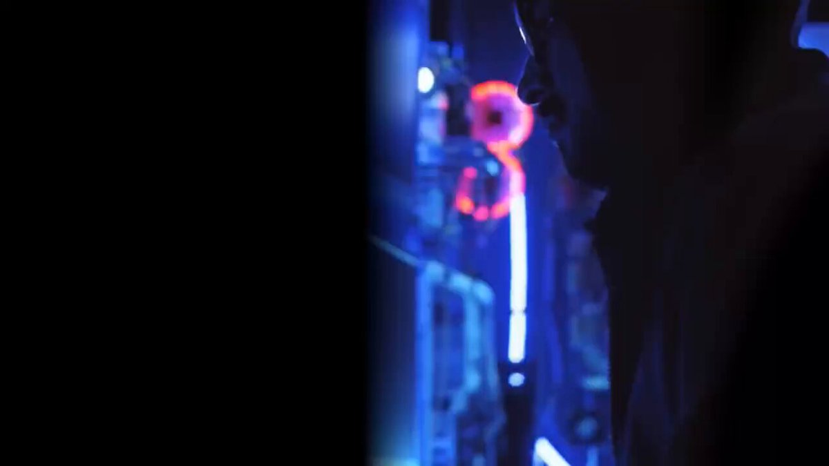 The image shows a man's face with his eyes closed, looking off into the distance. The background features neon lights that create an interesting contrast against the dark setting. There are also some words written below the photo, which seem to be related to the content of the image or the context in which it was taken.