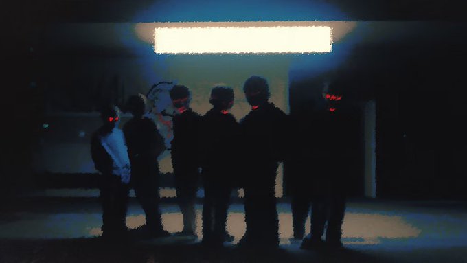 Five dark silhouetted figures stand in a dimly lit space beneath a bright horizontal light, with several of them featuring glowing red eyes.
