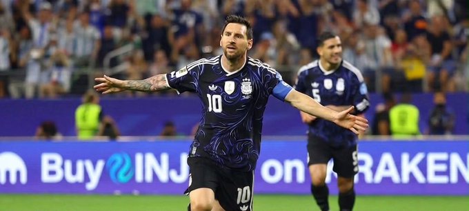 Lionel Messi (#10) celebrates with arms outstretched in Argentina's blue jersey, with a visible "Buy INJ on KRAKEN" ad banner in the background, cleverly connecting the football star's location at his "magic" performance to the Injective Summit happening nearby and the $INJ crypto mentioned in the post.
