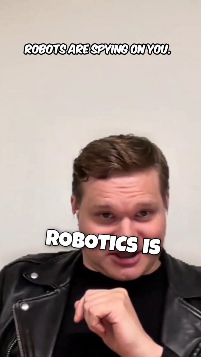 The image features a man wearing a leather jacket with his hand raised, as if he's about to make a gesture or point at something. The caption of the image reads "Robots are spying on you", which seems to be a playful way of referring to the idea that robots can potentially monitor and control our actions. The post also discusses power dynamics in relation to AI, asking whether it belongs to corporations, governments, or users themselves.