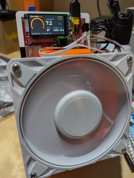 A photograph of a HAMMER brand cooling fan connected to a digital display screen showing temperature readings, likely part of a PC or mining rig setup.