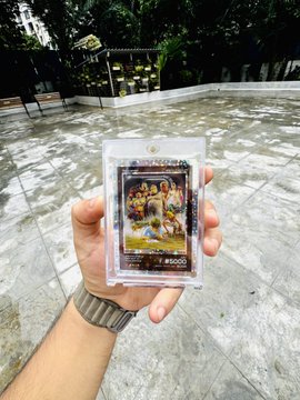 A hand holds up a graded Beeple "Everydays" trading card in a plastic slab with a 10 grade and serial number #10500, displayed against an outdoor courtyard background. The image showcases a rare collectible item, complementing the post's message about being an early supporter of Beeple's iconic digital art series.