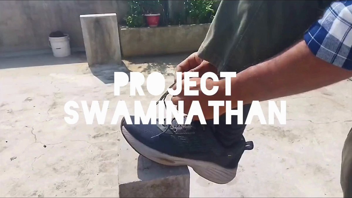 The image features a person wearing black shoes, with their foot resting on a stone block or cement slab. The background appears to be a concrete surface, possibly an outdoor patio area. There are no other people visible in the image.