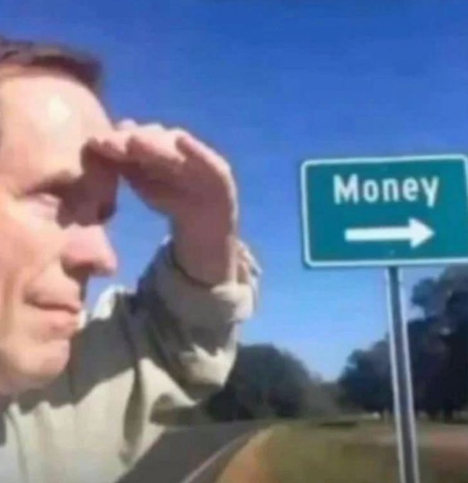 A man shields his eyes from the sun as he looks toward a green highway sign that reads 'Money' with an arrow pointing right.