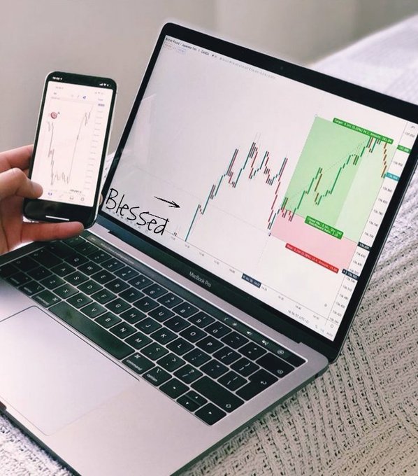 A hand holds a smartphone displaying a candlestick chart next to a MacBook Pro showing a larger version of the same financial chart with green and red zones labeled "Bearish TP" and "Bullish TP," with the word "Blessed" written beside an arrow pointing to a profitable trade entry—promoting free trading analysis from the Telegram channel t.me/FREEAnalysis6.