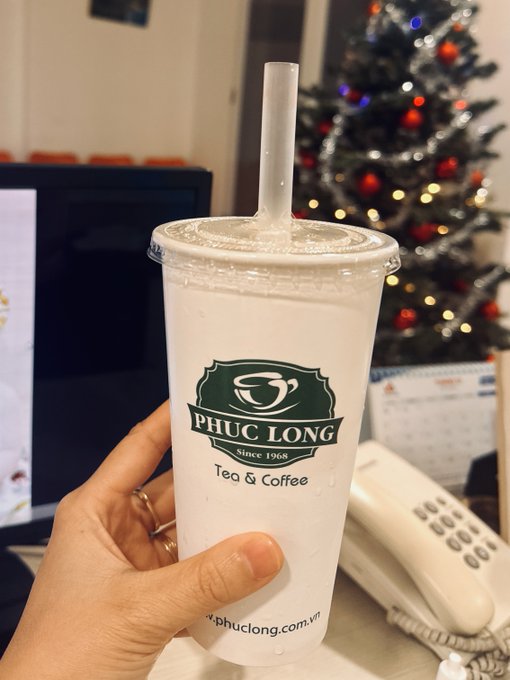 A hand holds a white plastic cup of Phúc Long Tea & Coffee (featuring the brand's green logo and website "www.phuclong.com.vn") in front of a Christmas tree. The image represents a meaningful gift from a friend who has since left the Web3 space, symbolizing the heartfelt personal connections the poster made during their time in the community.