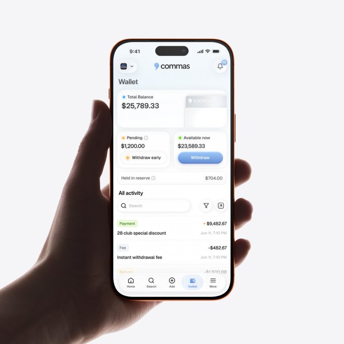 A hand holding a smartphone displaying the 'commas' app's Wallet screen, showing a Total Balance of $25,789.33, $1,200.00 pending, and an activity feed including a $9,482.67 payment labeled '28 club special discount.'