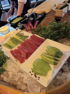 The image shows a plate of food with various ingredients, including asparagus, avocado slices, and possibly other vegetables or meats. The dish appears to be served on ice, which adds an element of freshness and coolness to the presentation. The background is blurred, but it seems like there might be some kitchen equipment or utensils present in the scene. The post that accompanies this image reads "Time $XRP". This could indicate that the food was prepared recently and is ready for consumption.