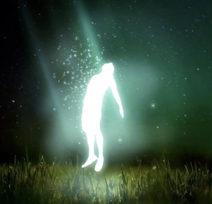 A glowing white silhouette of a human figure floating in a grassy field against a starry night sky with green aurora-like light rays.