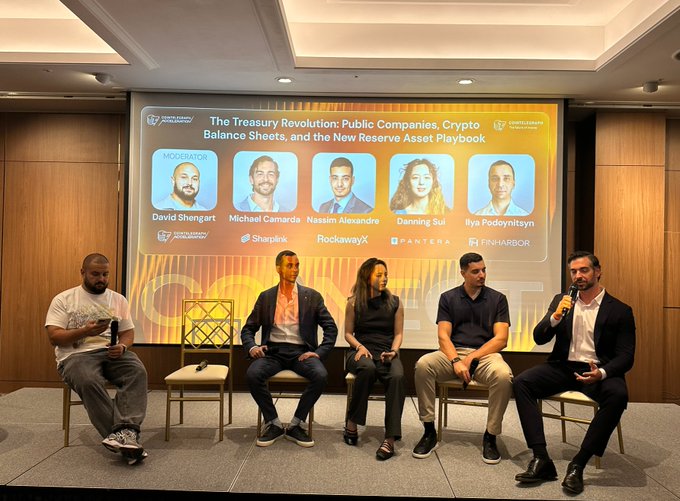 A panel discussion titled "The Treasury Revolution: Public Companies, Crypto Balance Sheets, and the New Reserve Asset Playbook" featuring moderator David Shengart alongside Michael Camarda (Sharplink), Nassim Alexandre (RockawayX), Danning Sui (Pantera), and Ilya Podolyatsyn (FinHarbor), with Danning Sui pictured on stage addressing questions about crypto treasury management strategies.