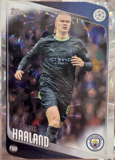 A Topps trading card featuring Erling Haaland in his Manchester City FWD jersey with Etihad Airways sponsorship, set against a holographic chrome background.