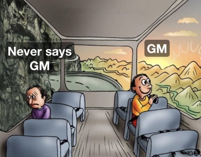 A popular meme illustration showing two people on a bus with different views out the windows—one sees a dark, gloomy forest labeled 'Never says GM', while the other sees a sunny mountain landscape labeled 'GM', referencing the crypto 'Good Morning' culture.