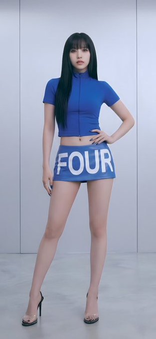 A young woman with long dark hair poses wearing a blue short-sleeved crop top and matching skirt with the word "FOUR" written across the front.