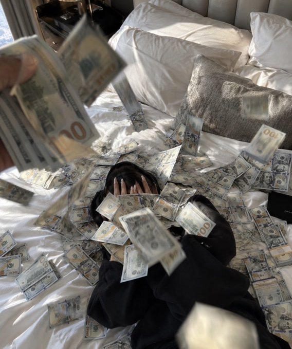 A person lies on a white-sheeted bed covering their face while hundreds of $100 US bills rain down and scatter across the bedding, with a hand in the foreground tossing more money into the air.

The image humorously contrasts with the caption's self-deprecating reflections on life's struggles—despite the person's complaints about lacking physical strength, intelligence, vision, social skills, and even memory for grudges, the scene of cash literally raining down suggests an ironic fantasy of financial abundance that remains far from their reality of worrying about family money.