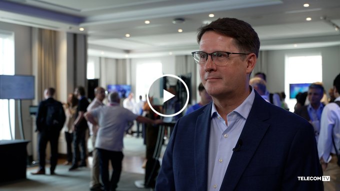 A video thumbnail showing a man with glasses in a blue blazer at a conference, with the TELECOMTV watermark.