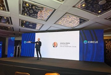 A photograph of Jeremy Allaire, Co-Founder, CEO & Chairman of Circle, speaking on stage at a Circle event with a blue branded backdrop.