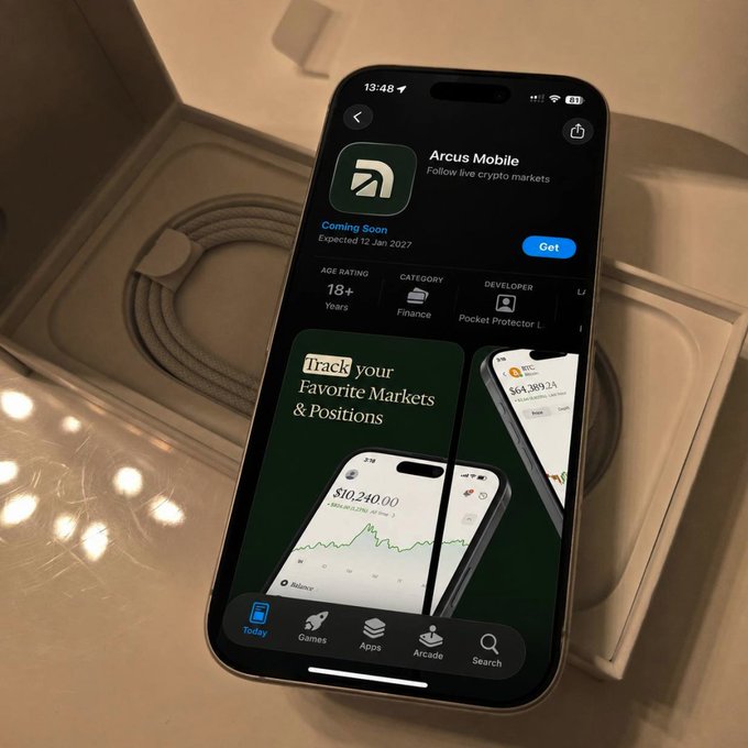 An iPhone resting on a box displays the upcoming "Arcus Mobile" app on the App Store, marked "Coming Soon" with an expected release date of 12 Jan 2027, featuring the tagline "Follow live crypto markets" and a preview screen showing market tracking at $10,240.00—visually supporting the post's inquiry about how to gain access to the Arcus platform.