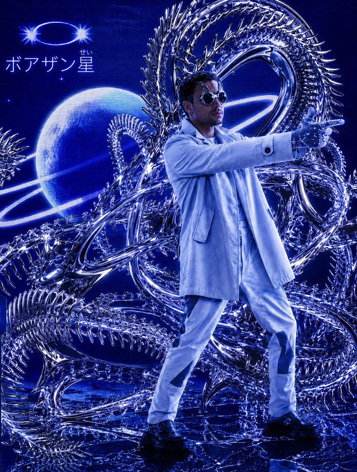 A man in a white suit and round sunglasses posing in front of a swirling, metallic silver structure and a blue ringed planet, with Japanese text 'ボアザン星' in the top left.