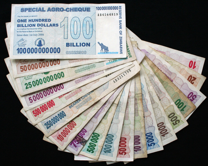 A fan of Zimbabwean "Bearer Cheque" banknotes fanned out across a dark surface, with the top note reading "SPECIAL AGRO-CHEQUE ONE HUNDRED BILLION DOLLARS" issued by the Reserve Bank of Zimbabwe in 2008.

The image illustrates the post's point about fiat currency fragility—the hyperinflated Zimbabwean dollar, which collapsed in 2008, serves as a vivid real-world example of how paper money can lose all value, echoing the article's caution against assuming any currency, including the U.S. dollar, has a guaranteed lifespan.