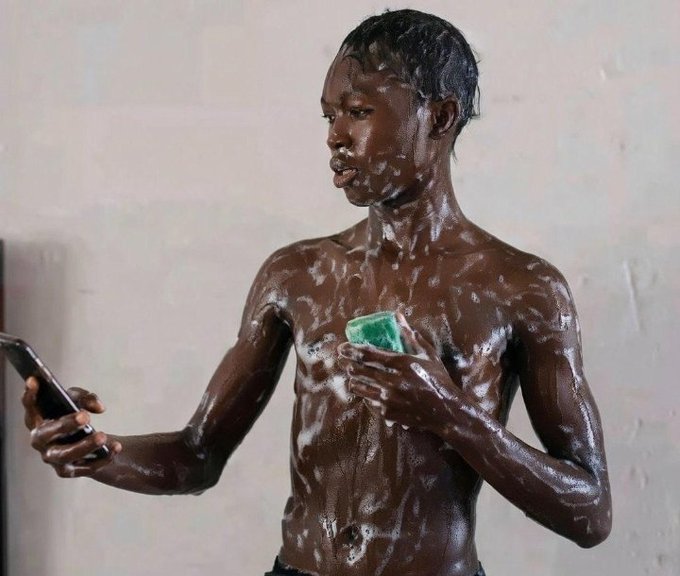 !"Gm CT Can I get a good morning back? Stay focused today @River4fun $River". The image features a shirtless man holding a green soap bar, possibly taking a selfie with his cell phone while standing against a white wall. The caption suggests that he is promoting a product or sharing his experience of using the soap bar on social media platforms like Instagram and Twitter.