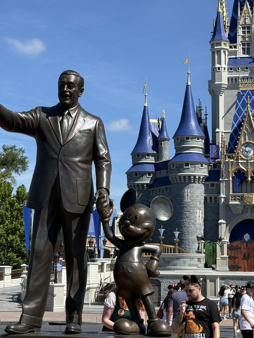 A bronze statue of Walt Disney holding hands with Mickey Mouse stands in front of Cinderella Castle at Walt Disney World's Magic Kingdom. The image, shared by a VeVe user as "Mint #0," likely promotes a digital collectible of this iconic partnership moment from the park's hub.