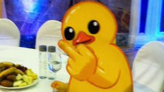 A classic rubber duck emoji-style figure sits on a dining table next to a plate of food, paired with a post promoting $UTYA as the "$SHIB on $GRAM" and tagging @telegram, @TonUtyacoin, @ton_blockchain, and @durov to highlight the coin as a bullish meme token. The cheerful duck visually represents the playful meme branding used to market the $UTYA coin.