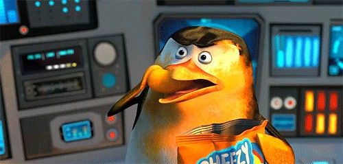 The image features a cartoon penguin holding an orange bag with a blue label that says "Cheez-it" written on it. The penguin appears to be standing next to a control panel, which suggests that they are in a space setting or possibly aboard a spaceship. The background of the image is dark and out of focus, drawing attention to the penguin and its surroundings.