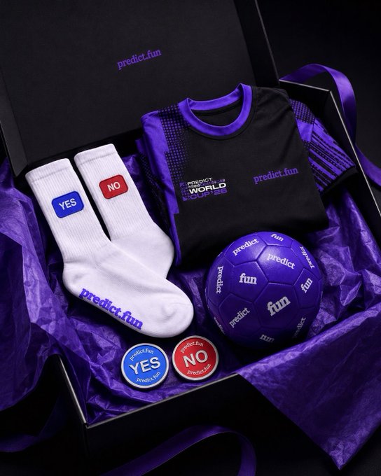 The image features a gift box containing various items, including socks with "No" stickers, a soccer ball, and other sports-related merchandise. The text "@predictdotfun" appears multiple times throughout the scene, possibly indicating that this is an advertisement or promotional material for a product related to predicting the outcome of sporting events.

The gift box is placed on a black background with purple wrapping paper, creating a visually appealing and cohesive presentation. The items inside the box are arranged in such a way as to draw attention to their contents while maintaining a sense of balance within the overall composition.
