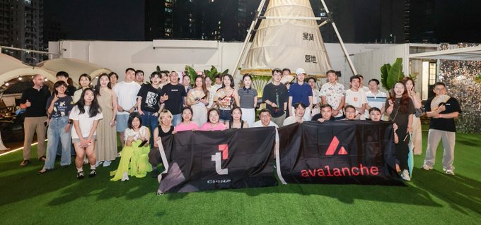 The image features a large group of people posing together for a photo, with some holding up banners or flags. The text "Team 1" can be seen among them, indicating that they are part of a team or organization. The background includes a building and trees, suggesting an outdoor setting. The post reads "我们还将继续在各地举办活动", which implies that the group is actively involved in some form of activity or event related to Team 1.

The image also contains a reference to a company called "Team 1" and an event, possibly a party or gathering. The people are standing on a green field, with a building visible in the background.