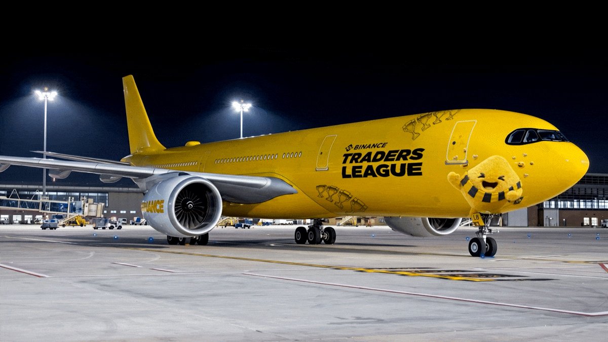 The image shows a large jetliner from the Traders League company parked at an airport runway, with "Futures phase just landed in the Traders League." The jetliner appears to be well-maintained and ready for its next journey, potentially participating in the Futures Challenge competition. The post also mentions the top 500 finishers on the leaderboard winning $500,000 prizes.