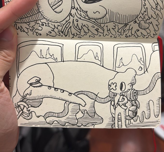 An open sketchbook displays intricate black-and-white ink doodles, with the bottom page featuring a surreal scene of a long-beaked creature-like figure and a mushroom-headed character with framed pictures on the wall behind them.