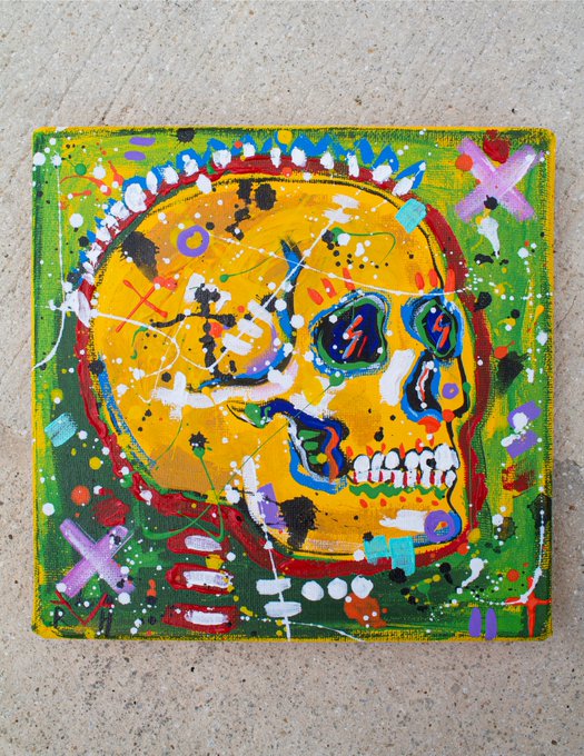 A colorful, stylized painting of a yellow skull with X-shaped eyes on a green background, rendered in a street art or graffiti style on canvas.