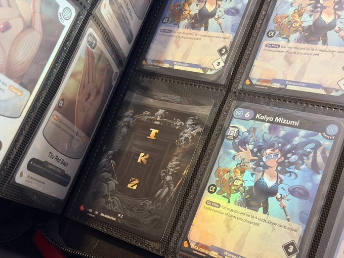 A collection of trading cards in protective sleeves, including a 'Kaiya Mizumi' Wavecaller card and a 'TRZ' card, displayed in a binder.