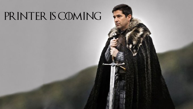 A meme image of a man dressed as a Game of Thrones Night's Watch character holding a sword, with the text 'PRINTER IS COMING' styled in the Game of Thrones font.