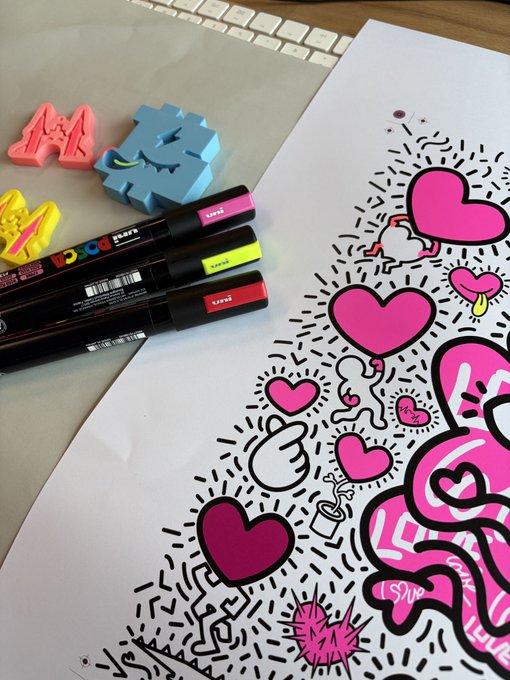 POSCA markers in pink, yellow, and red lie next to colorful 3D-printed letters spelling 'AMOR', beside a black-and-white doodle artwork featuring various pink hearts and patterns.
