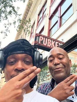 Two men pose playfully in front of a "PUBKEY" sign, with the post crediting them for their contributions at @QntmExpeditions and tagging notable figures like @douglashardwick, @MatiGreenspan, and @MadHattter___.