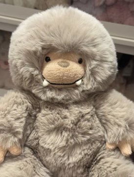 A fluffy gray Bigfoot plush toy from the Jellycat "Bigfoot" series sits on display, featuring the character's signature shaggy fur, gentle smile, and small tusks. The post excitedly announces finding this adorable creature at the mall and bringing it home as a delightful surprise.