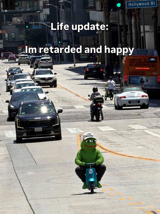 A mutated meme showing Kermit the Frog riding a small blue moped down Hollywood Boulevard, overlaid with the text 'Life update: Im retarded and happy'.