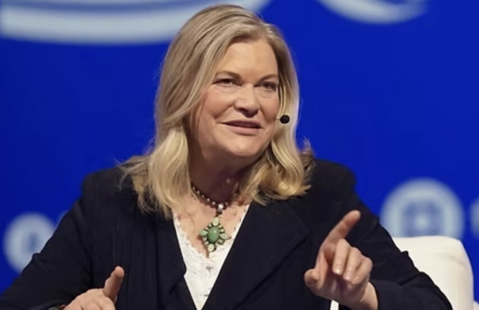 Senator Cynthia Lummis, with blonde hair and wearing a black blazer over a white top with a turquoise pendant, speaks at a podium with a blue backdrop, gesturing with her hands as she discusses the Clarity Act as a generational contribution to America's legacy.