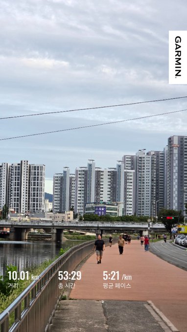 Garmin fitness tracking screenshot showing a run in a Korean city: 10.01 km, 53:29 total time, 5:21 /km pace, with apartment buildings along a river.