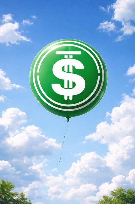 A shiny green balloon featuring the white USD Coin ($) logo floats against a bright blue sky dotted with fluffy white clouds, with green treetops visible at the bottom of the frame.
