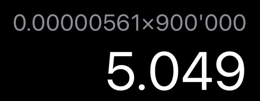 A simple black screen displaying the mathematical equation '0.00000561×900'000' with the calculated result '5.049' shown in large white numbers below.