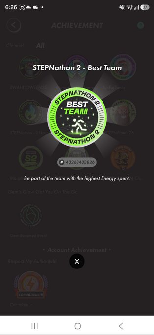A mobile screen shows a STEPN achievement popup titled "STEPNathon 2 - Best Team" with badge ID 43263483826, celebrating the user's team achievement for having the highest Energy spent. The Japanese caption explains that while the 42k badge wasn't earned, there is still a sense of accomplishment, thanking fellow "Achiever" participants for the experience.